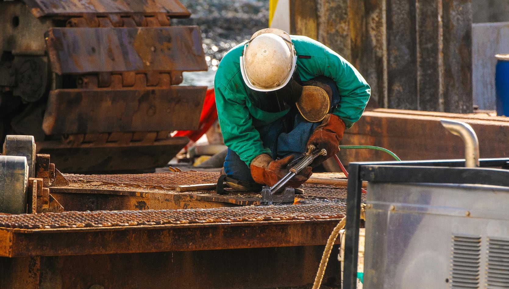 man wearing protective gear and welding on construction site