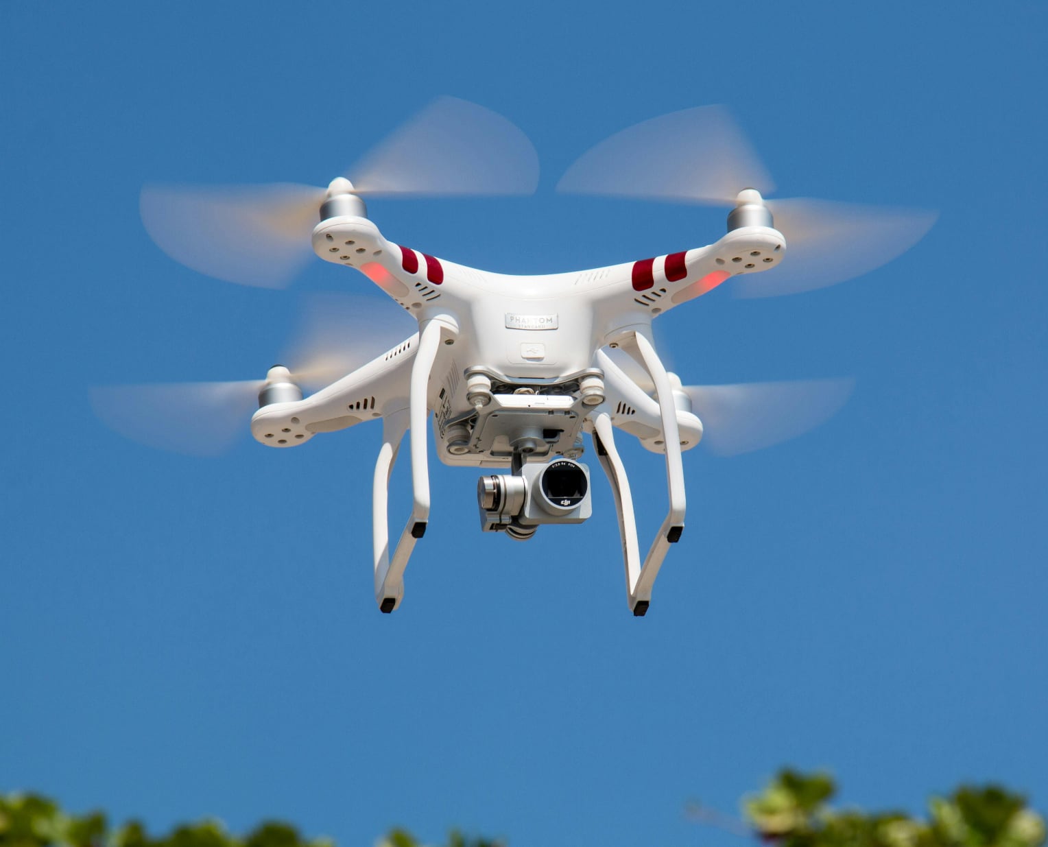 white quadcopter drone with camera on a blue sky