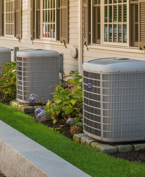 air conditioners sitting in front of town houses 